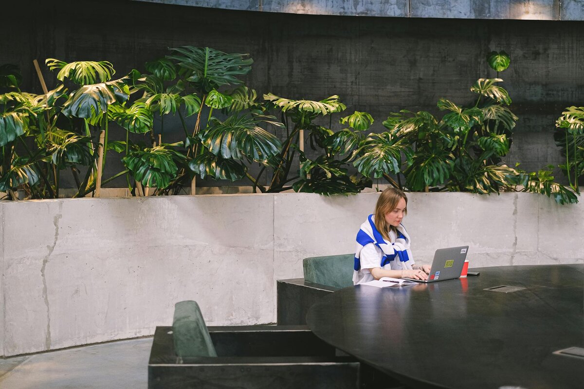 lady on laptop with greenery behind