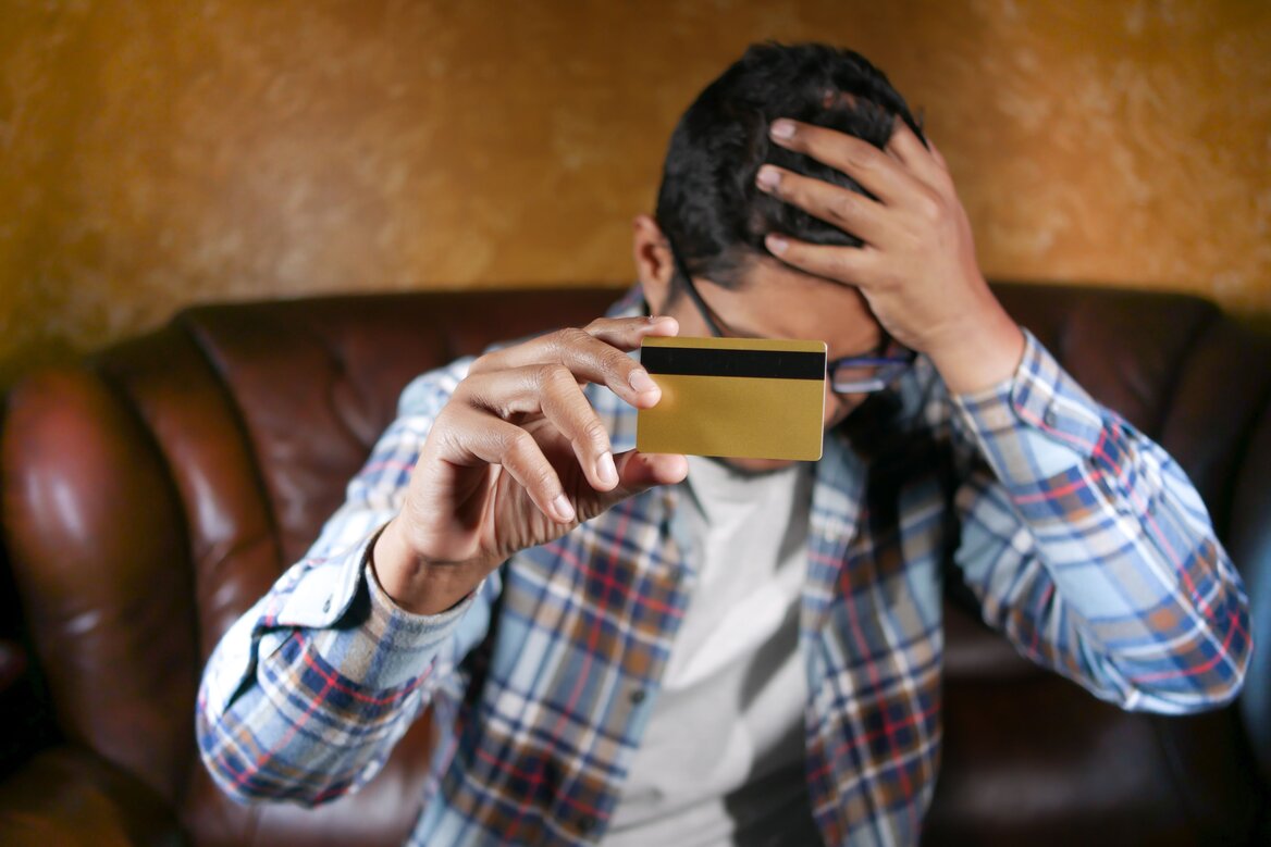 Stressed man holding his ISA card because of withdrawal penalty