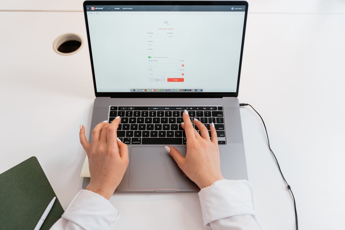 Close-up of hands typing on a laptop while filling in account details on a secure online form