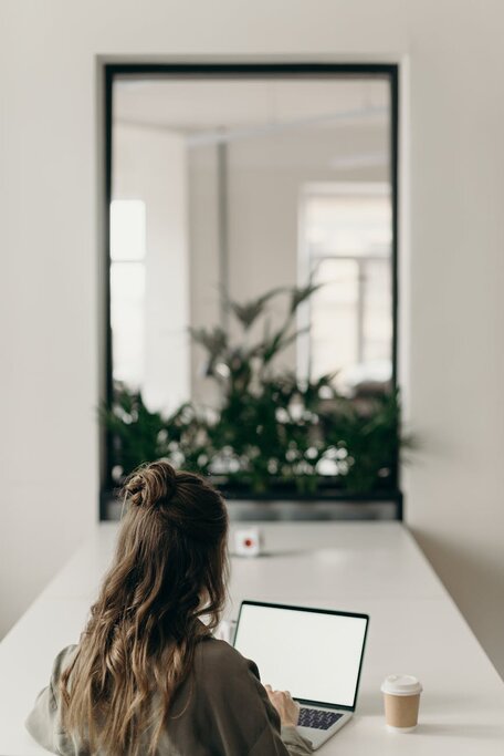 lady looking at laptop with coffee