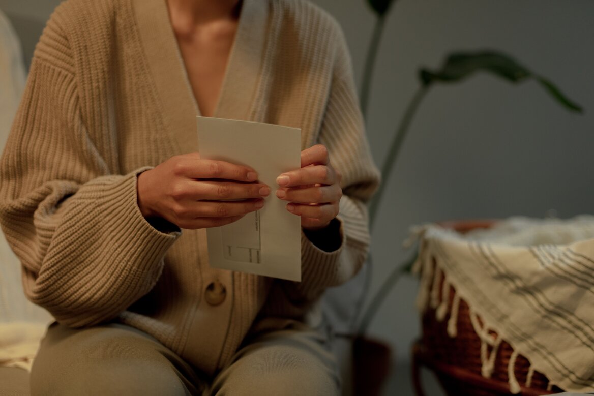 person-opening-official-letter-at-home.jpg