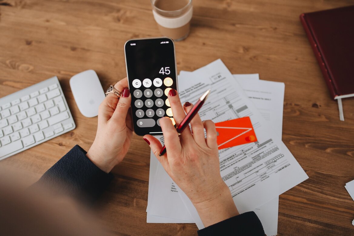 Woman using a calculator app for Managing taxes for 2024