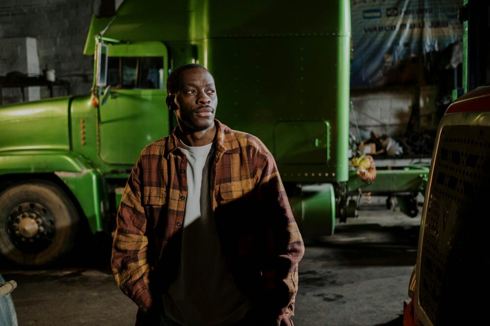 man standing Infront of green truck