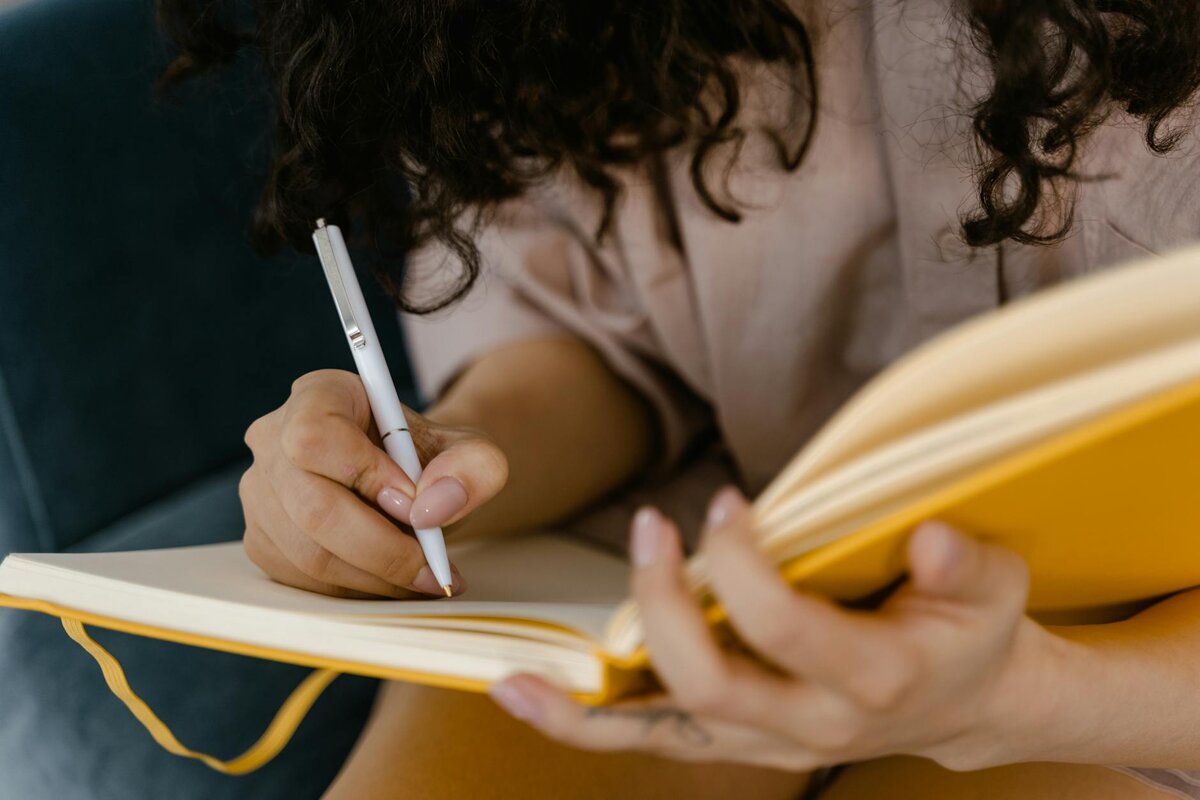a woman writing on her notebook 