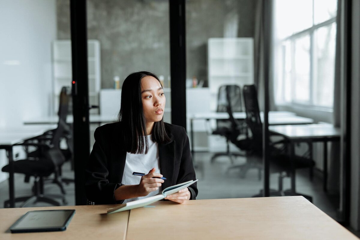 Woman holding a pen and a notebook