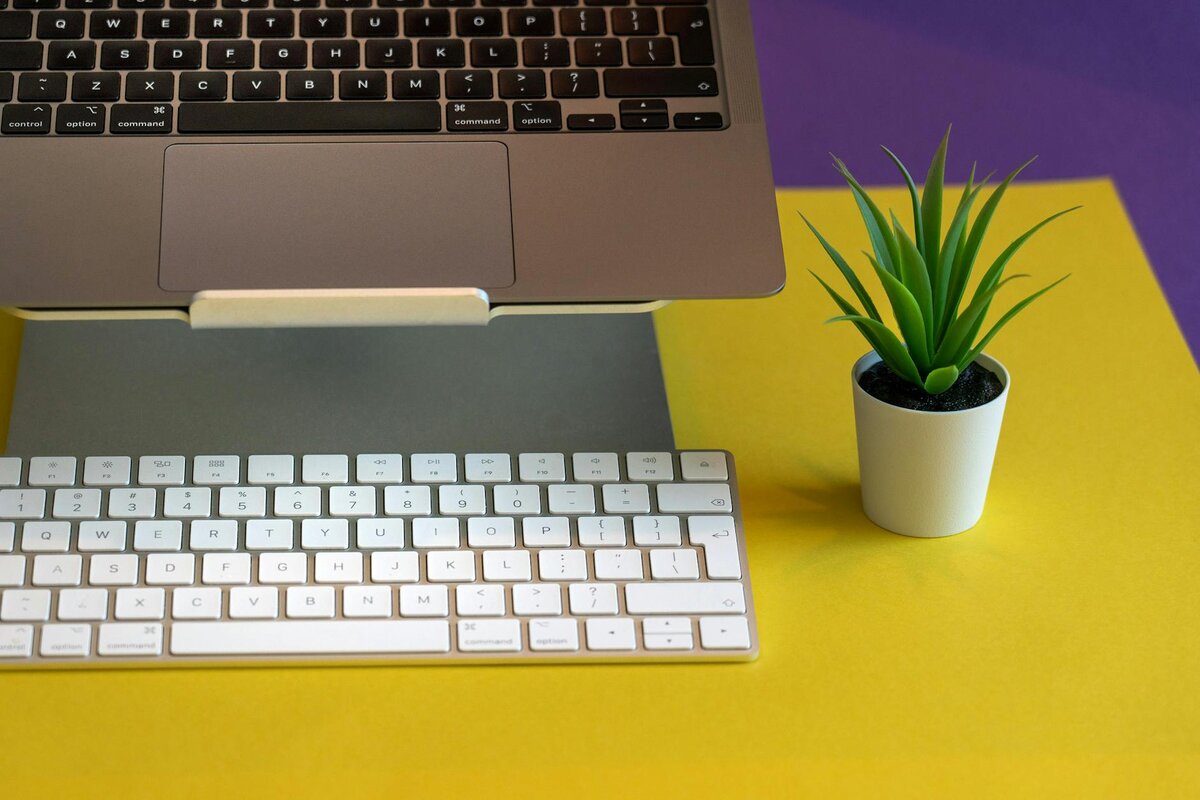 laptop and keyboard on yellow table 