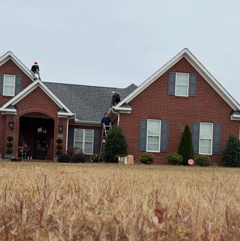 Installers working on the roof of a brick home