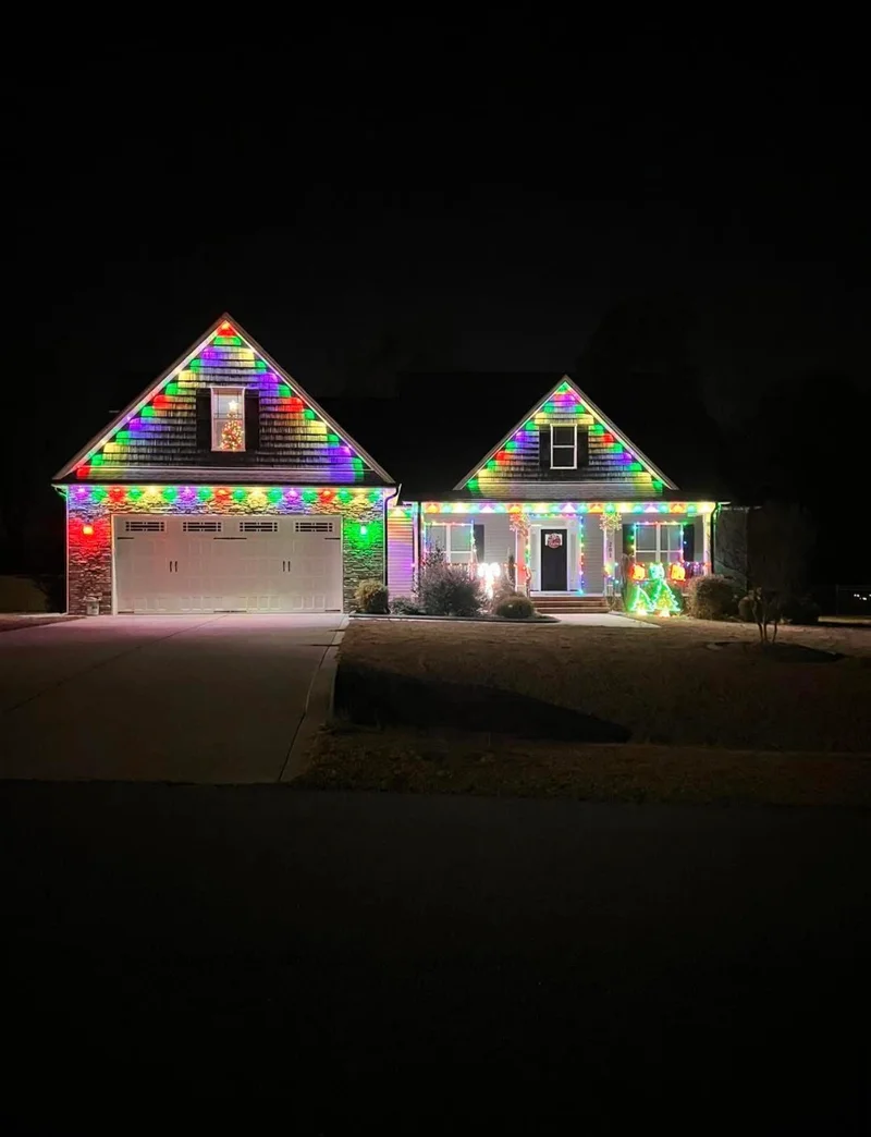 Gabled home decorated with bright rainbow holiday lights
