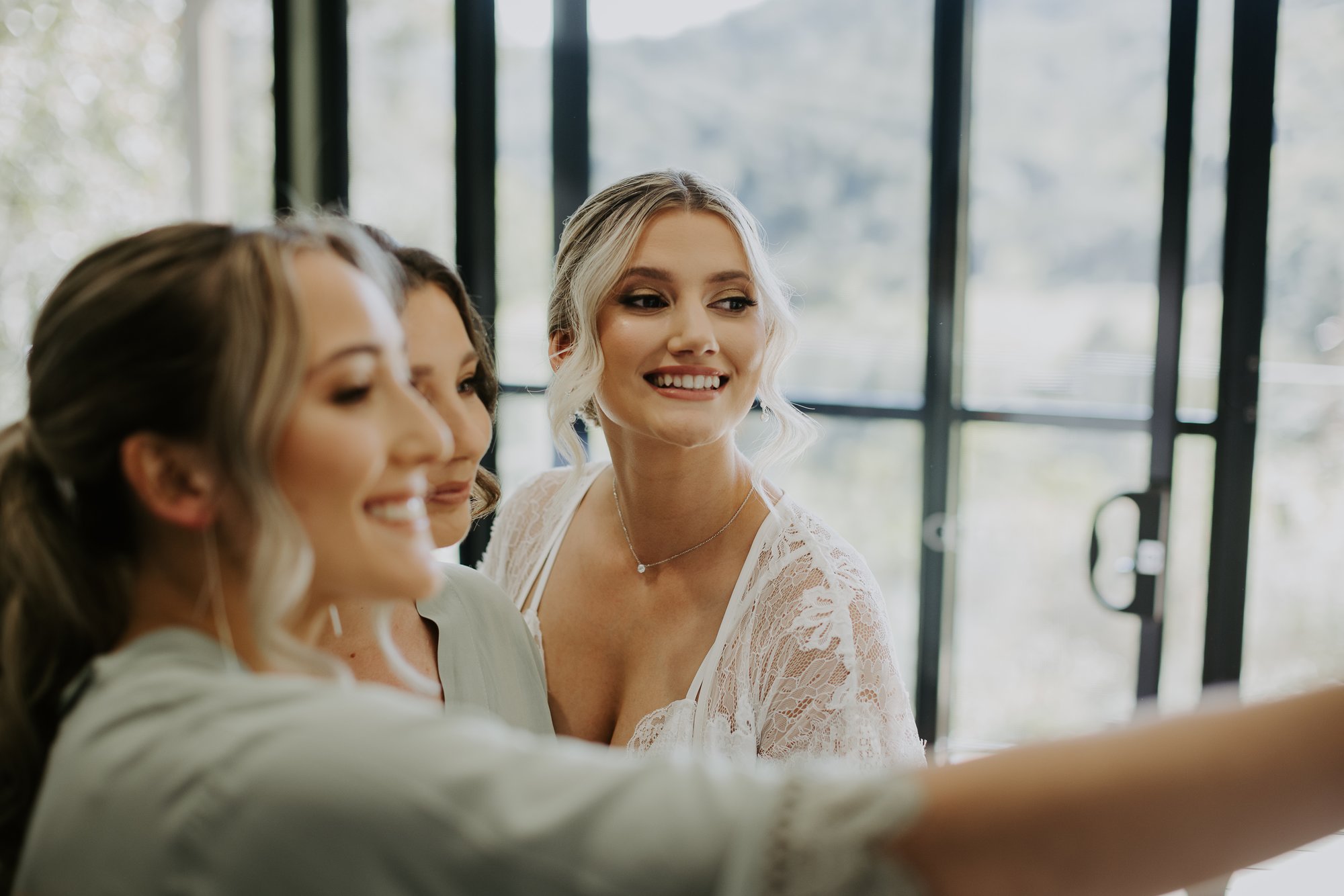 Natural look bride and bridesmaids taking a selfie