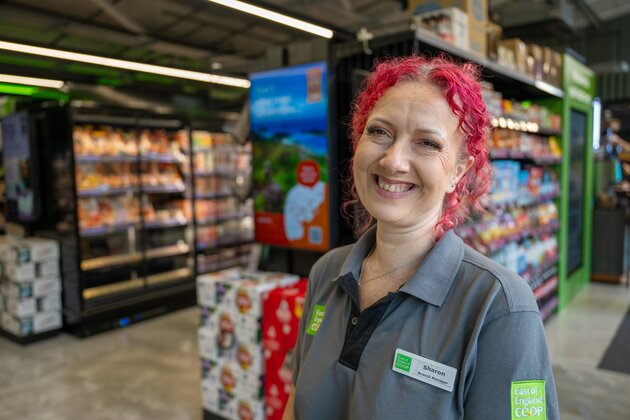 East of England Co-op colleague smiling in store uniform, representing careers opportunities.