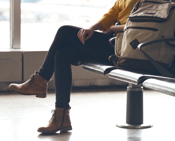 A view of a woman's feet sitting at an airport window.