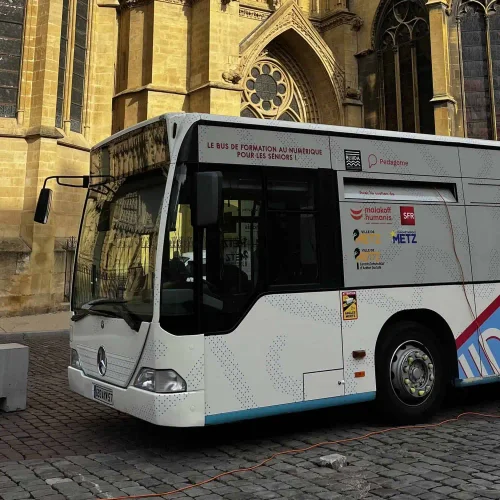 Un bus aménagé en salle de formation devant la cathédrale de Metz