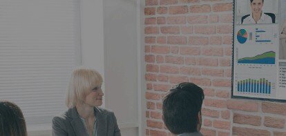 A corporate team in a conference room attending a video call with another team