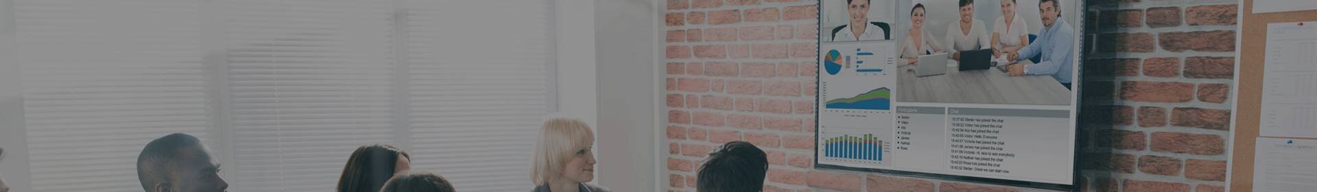 A corporate team in a conference room attending a video call with another team
