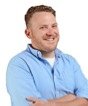 Photo of Ryan Bradley, in a light blue shirt overlooking a white silhouette