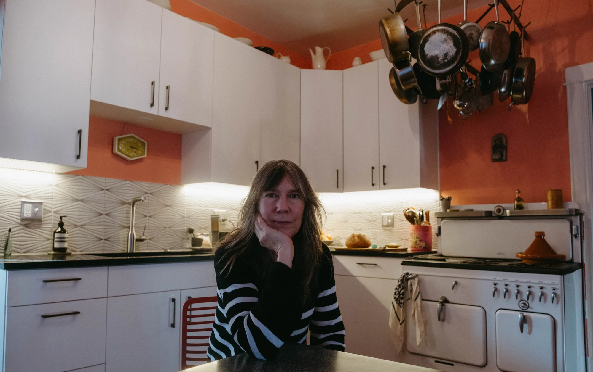 Jennifer Redies sitting in her pink kitchen. Before scaling to commissary kitchens, Redies cooked all her meals in her home kitchen. Photo: Peter Vo, Rocky Mountain PBS