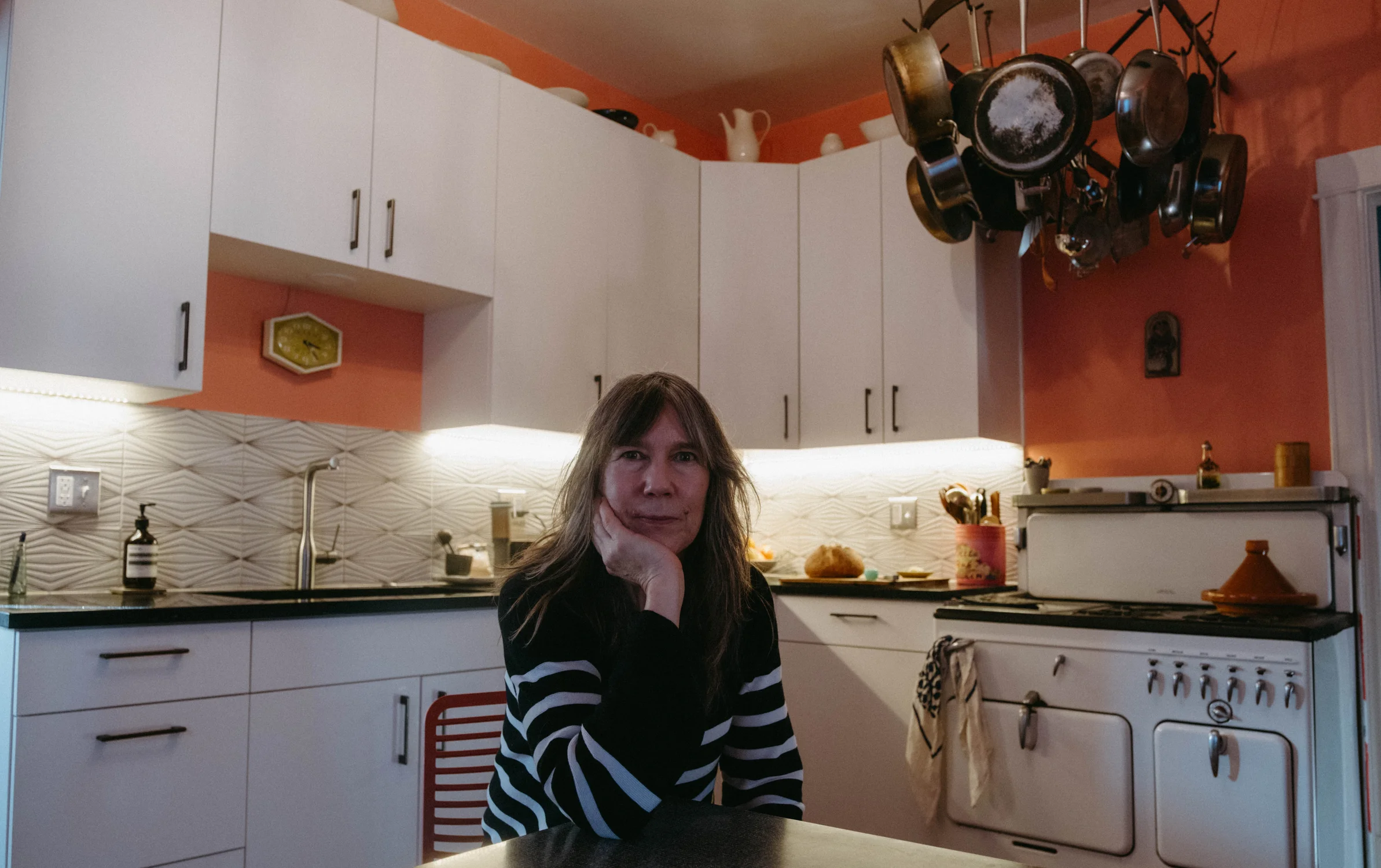 Jennifer Redies sitting in her pink kitchen. Before scaling to commissary kitchens, Redies cooked all her meals in her home kitchen. Photo: Peter Vo, Rocky Mountain PBS