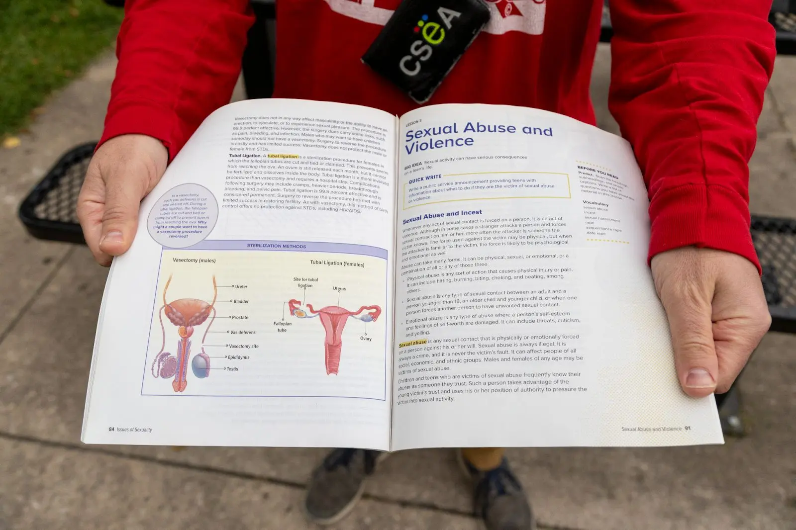A teacher holds the supplemental textbook whose pages were removed to censor information on gender identity. Photo: Chelsea Casabona, Rocky Mountain PBS