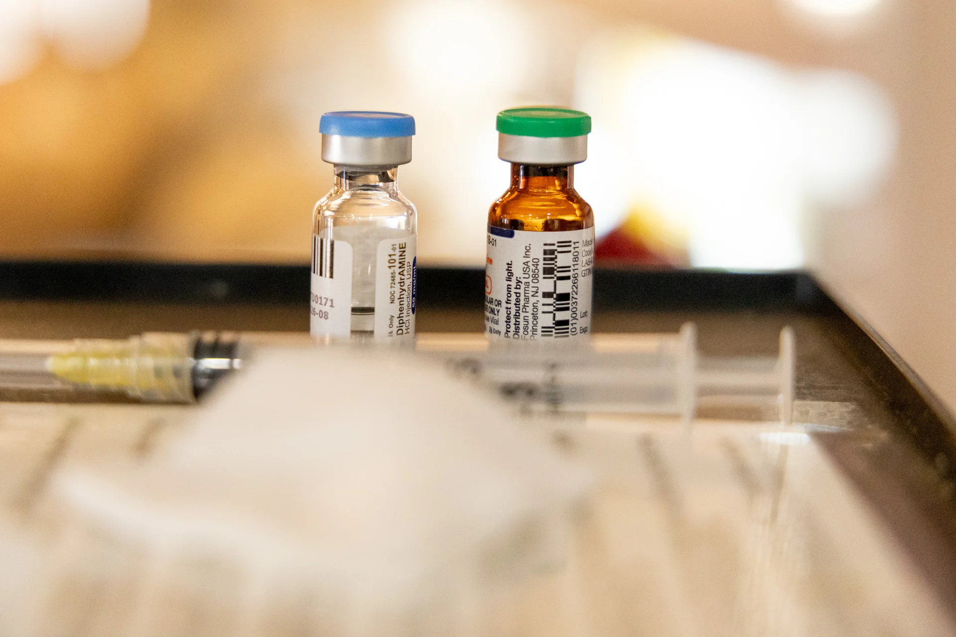 Shown is a small vial of the antihistamine diphenhydramine and a vitamin IV solution, which is added to an IV bag. Photo: Priya Shahi, Rocky Mountain PBS