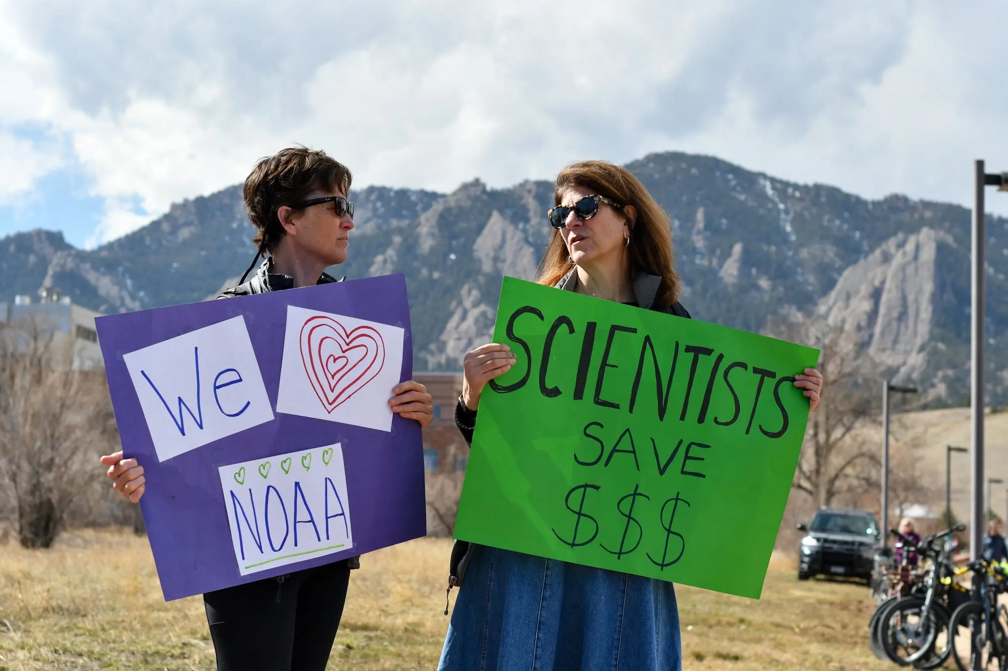 Protesters hold signs at a demonstration in Boulder, Monday, March 3, in support of NOAA workers whose positions were eliminated as part of the Trump administration's mass firing of federal workers. Photo: Cormac McCrimmon, Rocky Mountain PBS