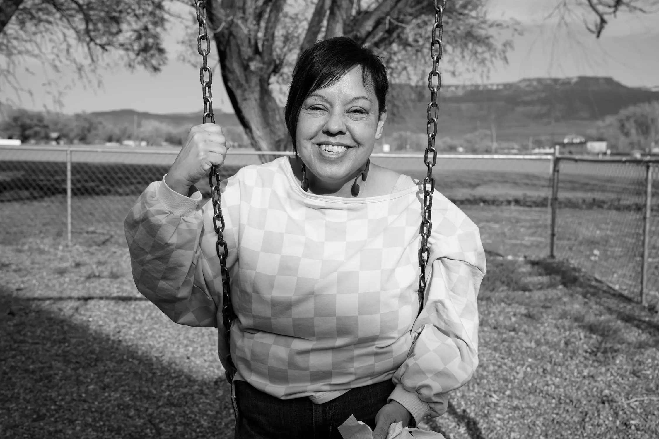 Kathy Inman takes a break from swinging to pose for a portrait on the playground at the church. Photo: Joshua Vorse, Rocky Mountain PBS