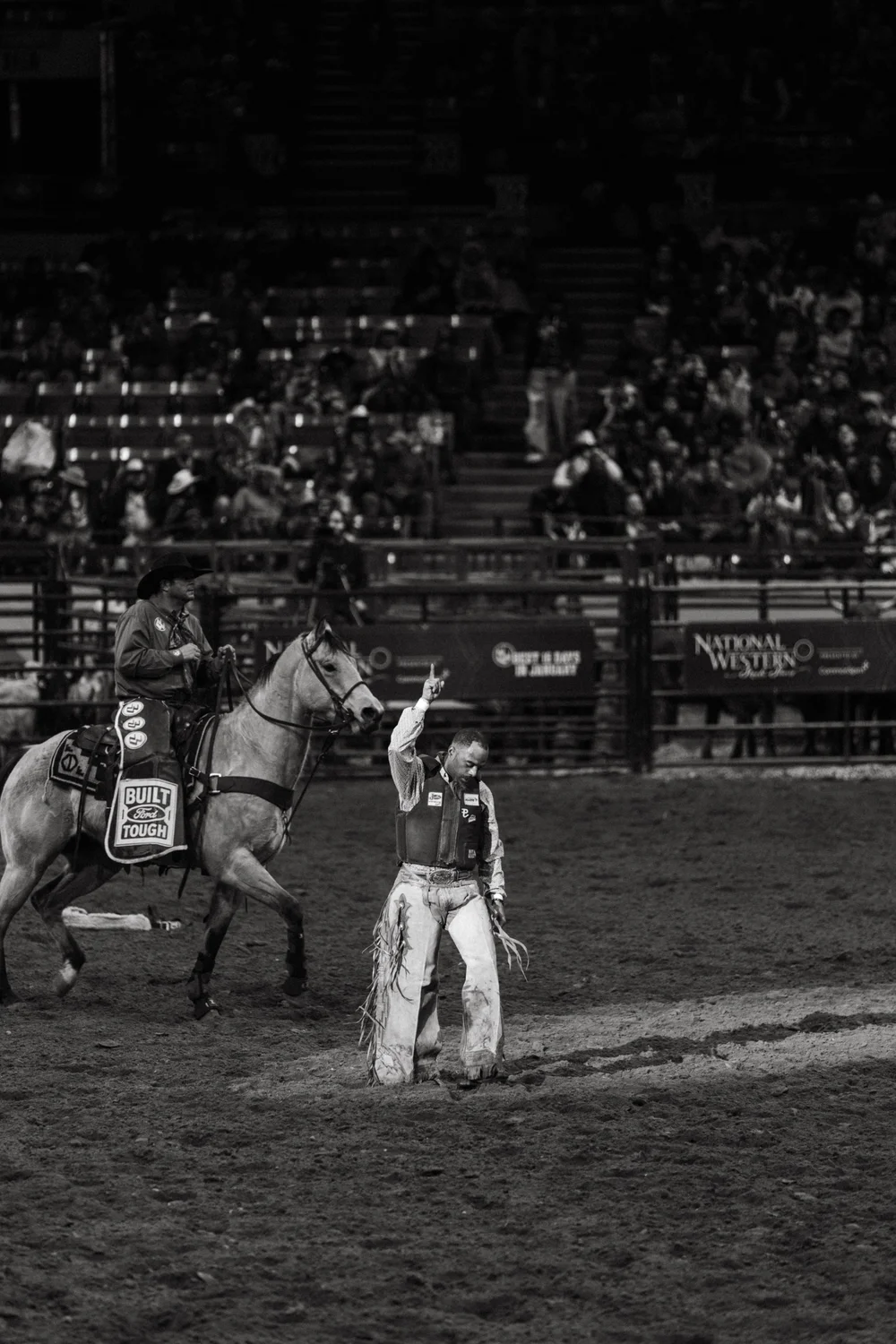  A cowboy point up to the sky after bronc riding.