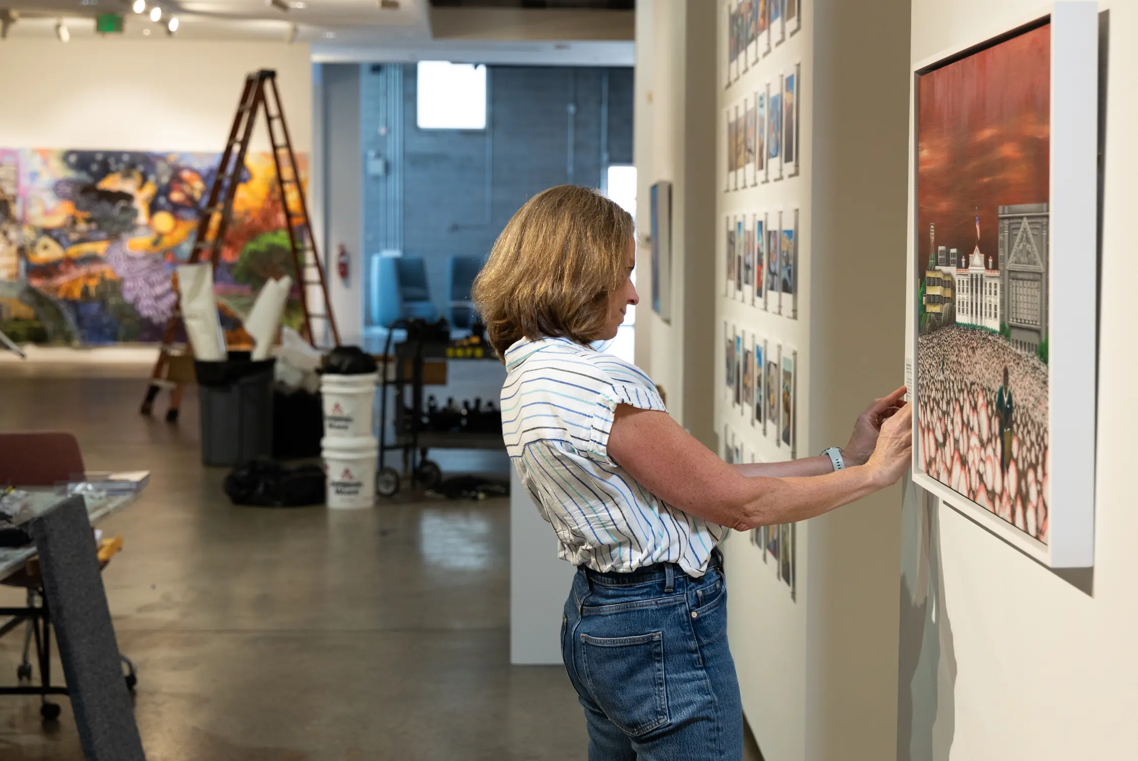 Sarah McKenzie, one of the curators of the “High Walls” exhibit and Unchained Voices installation, helped prepare the gallery before the show opened. Photo: Carly Rose, Rocky Mountain PBS