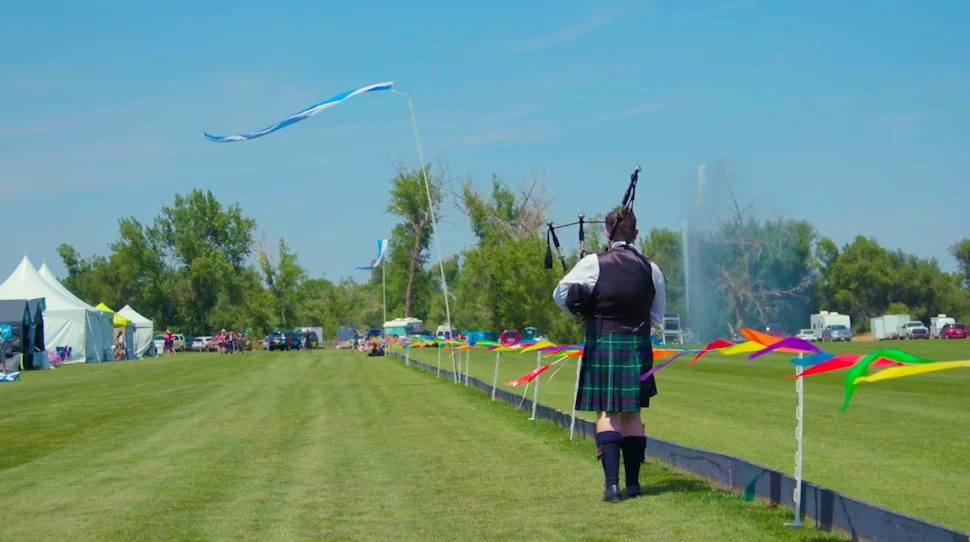 A bagpiper warms up his pipes in front of one of the many Scottish flags flying at the Colorado Scottish Festival. Photo: Chase McCleary, Rocky Mountain PBS