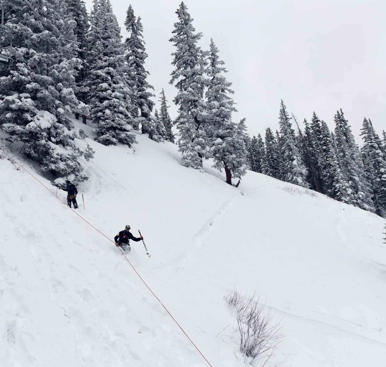 A ski patroller descends a fixed line under the Deep Temerity lift line. On slopes with elevated avalanche risk, bootpackers wear a harness and self-belay device. Photo: Cormac McCrimmon, Rocky Mountain PBS