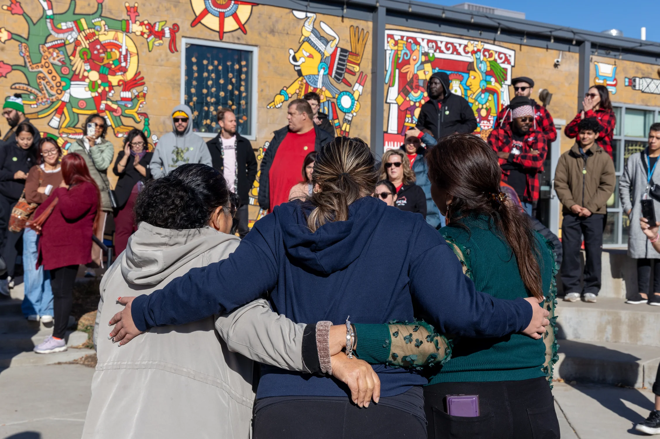 Inda Vergara, Zamira Pinon and Mayra Olivas embrace after speaking at the rally. Olivas was fired in May after sharing her concerns about Re:Vision’s leadership to the board. Vergara and Pinon were fired less than two weeks after unionizing. Photo: Carly Rose, Rocky Mountain PBS