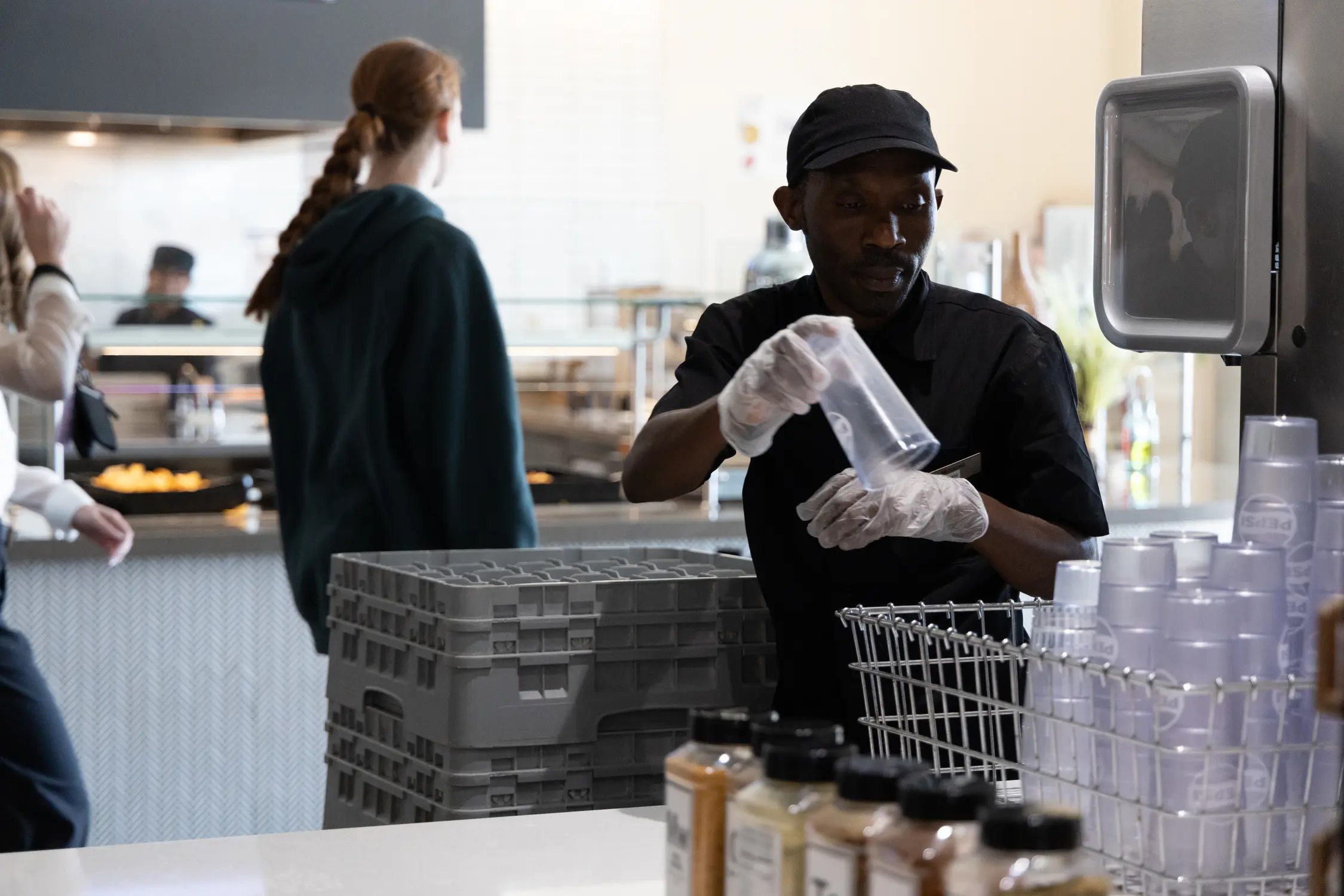 About one-third of the staff that service the University of Denver’s dining hall are newly arrived refugees, including Bunani Zayirwa (right), from the Democratic Republic of the Congo. Photo: Andrea Kramar, Rocky Mountain PBS