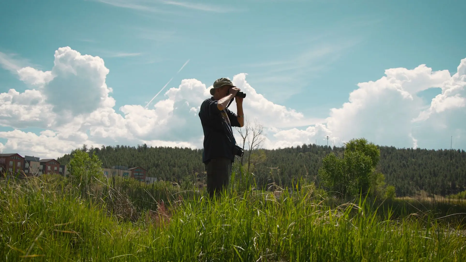 Ben Bailey observing birds by the wetland. Photo: Ziyi Xu, Rocky Mountain PBS