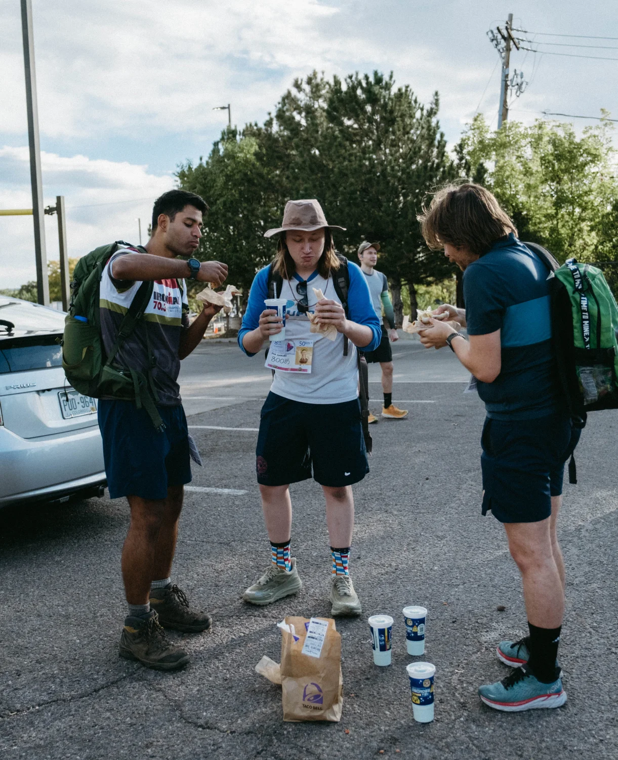 Three runners eat Taco Bell in the parking lot of the second stop. Photo: Peter Vo, Rocky Mountain PBS