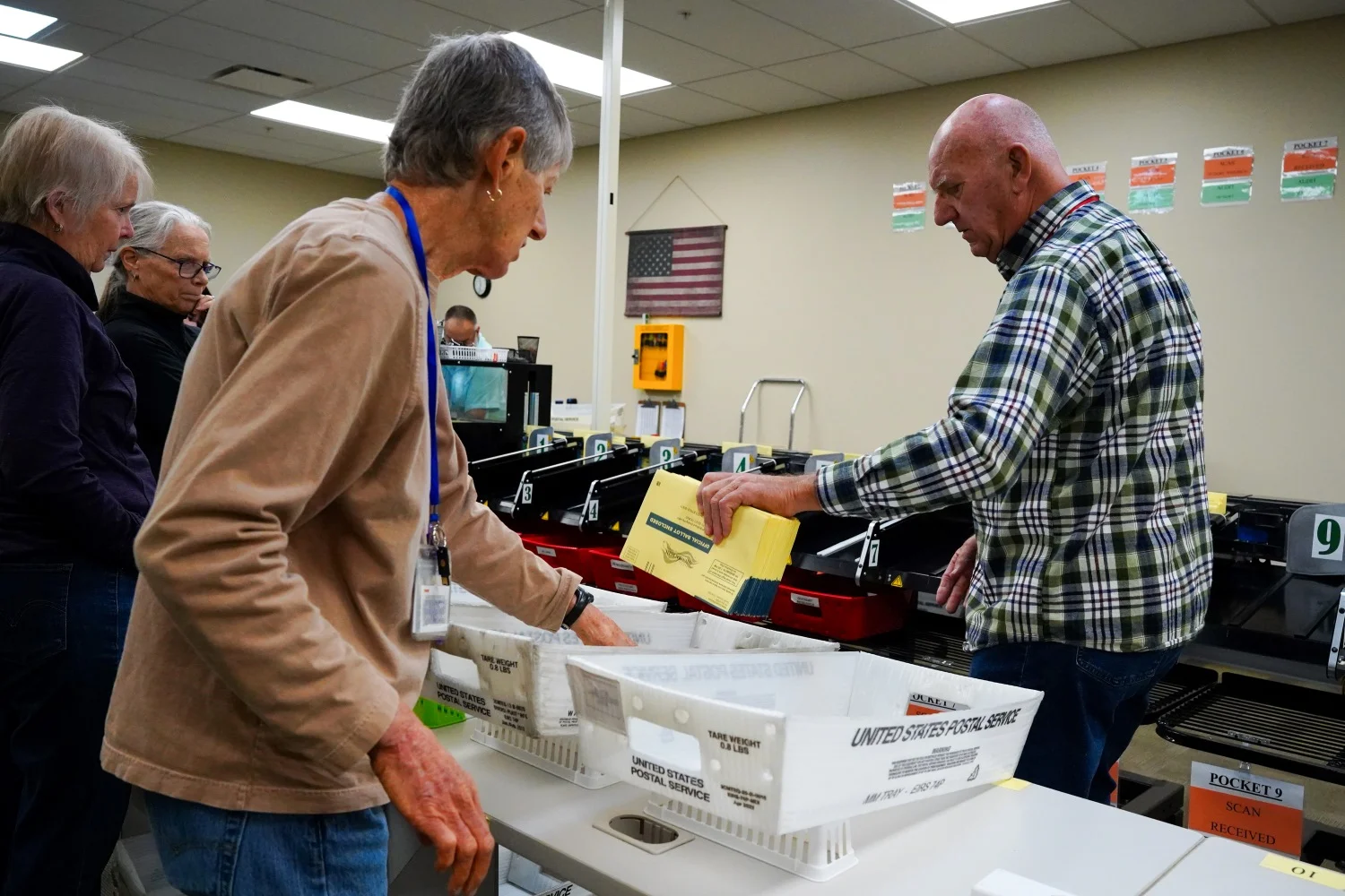 Election judges in Mesa County take ballots out of the scanning and sorting machine before they're moved to the next station in the process. Photo: Joshua Vorse, Rocky Mountain PBS