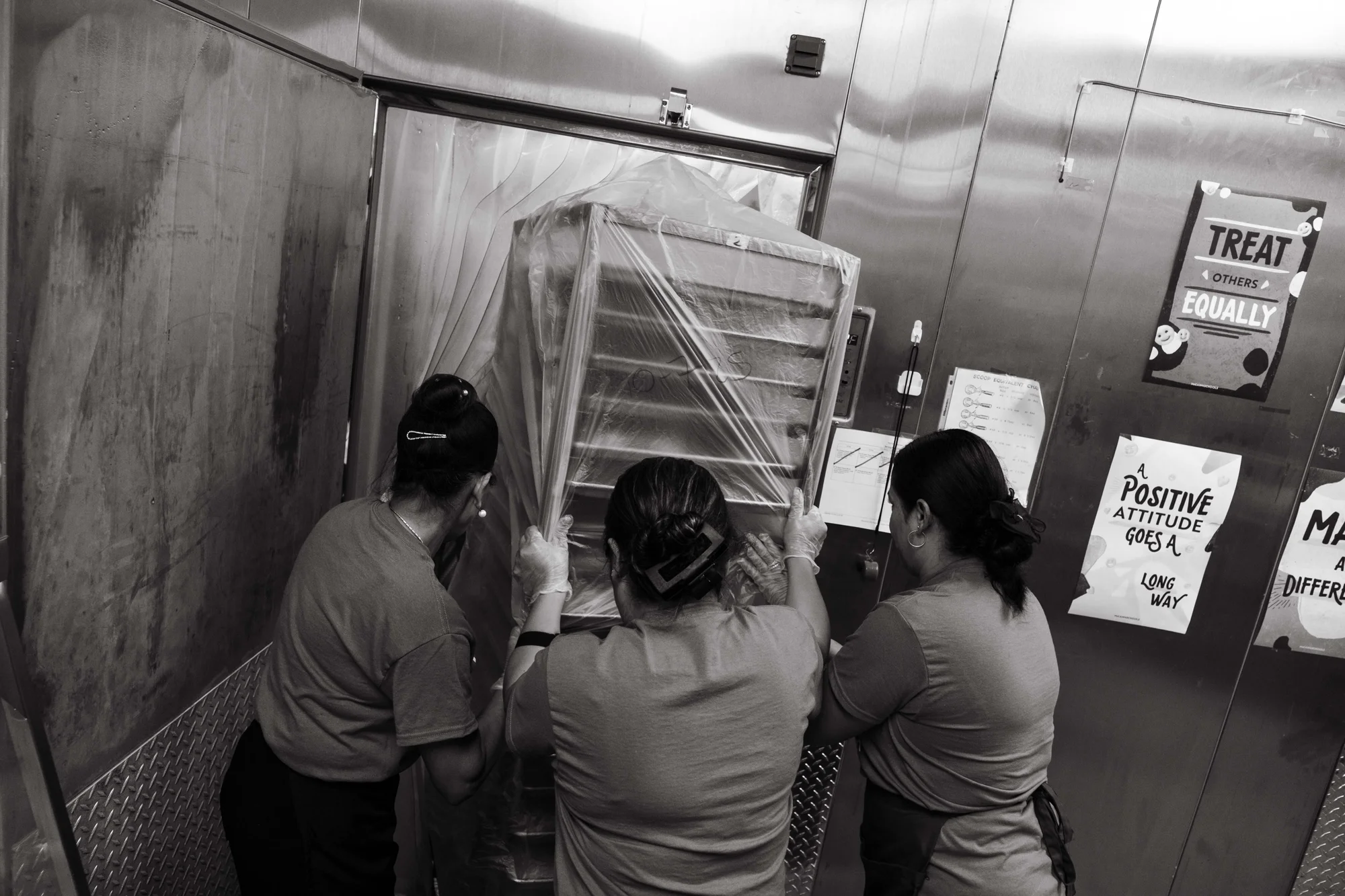 Cafeteria workers push a cart of frozen chicken nuggets into the walk-in cooler.  Photo: Peter Vo, Rocky Mountain PBS