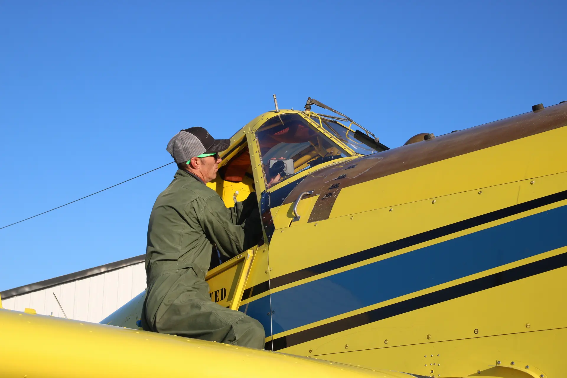 Pilot Neil Wicke readies his plane before a seed spraying mission in August. Wicke learned to fly at Aims Community College in Greeley. Photo: Emma VandenEinde, KUNC. 