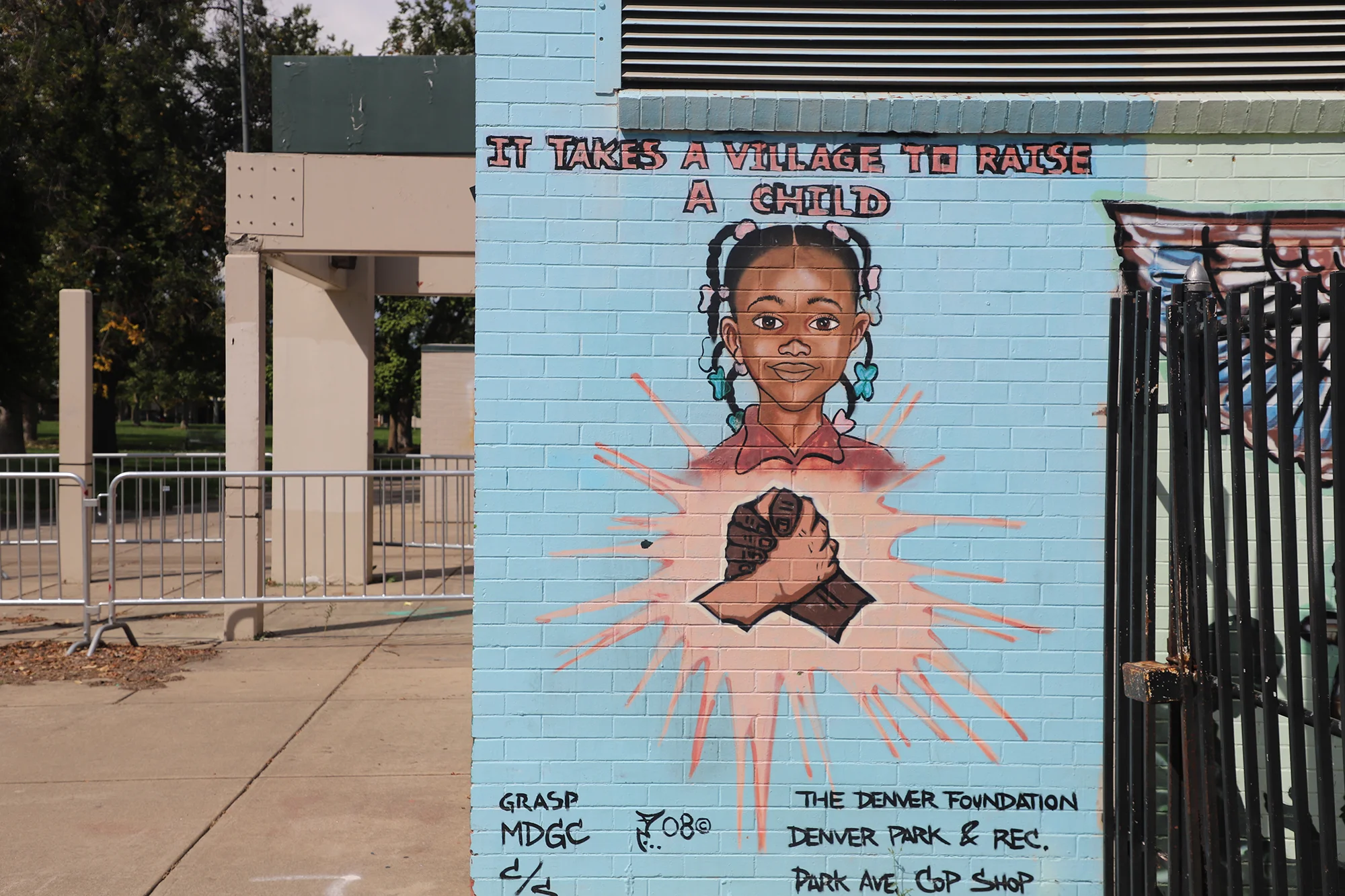 A mural outside the pool reads "It takes a village to raise a child." Photo: Alec Berg, Rocky Mountain PBS