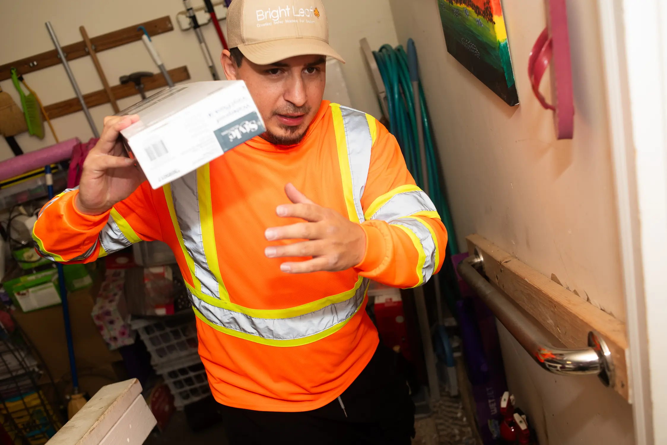 Steven Olguin of Bright Leaf hauls one box of flooring out of Lori Kratzer's garage. He received 350 square feet of donated flooring to complete Kratzer's living room. Photo: Cormac McCrimmon, Rocky Mountain PBS