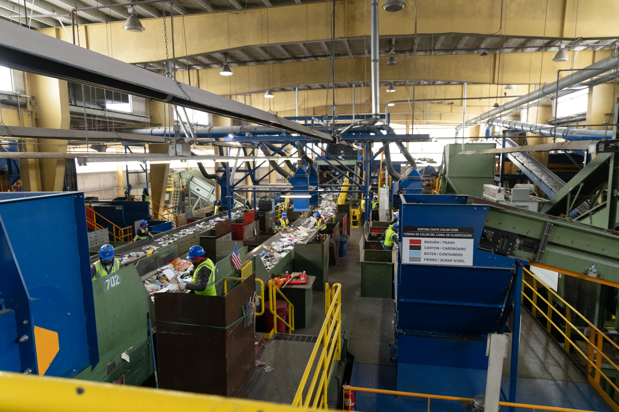 Workers hand sort material off the conveyer belt at Boulder County Recycling Center. The county, like most, offers single-stream recycling to residents, so the facility must separate paper, plastics, glass and metals.  Photo: Andrea Kramar, Rocky Mountain PBS 