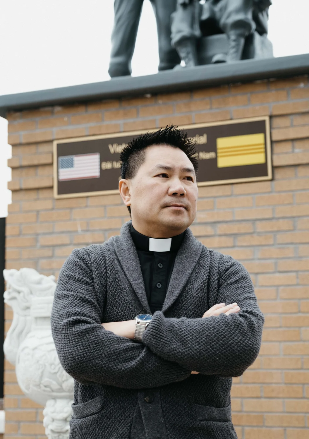 Father Dang stands in front of the memorial. Photo: Peter Vo, Rocky Mountain PBS