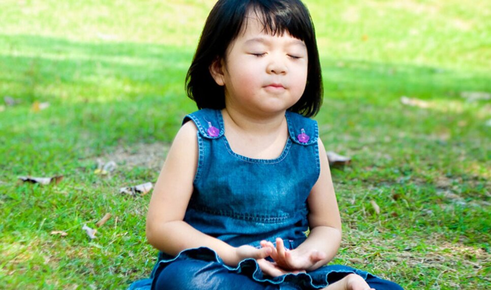 Child with eyes closed sitting in the park