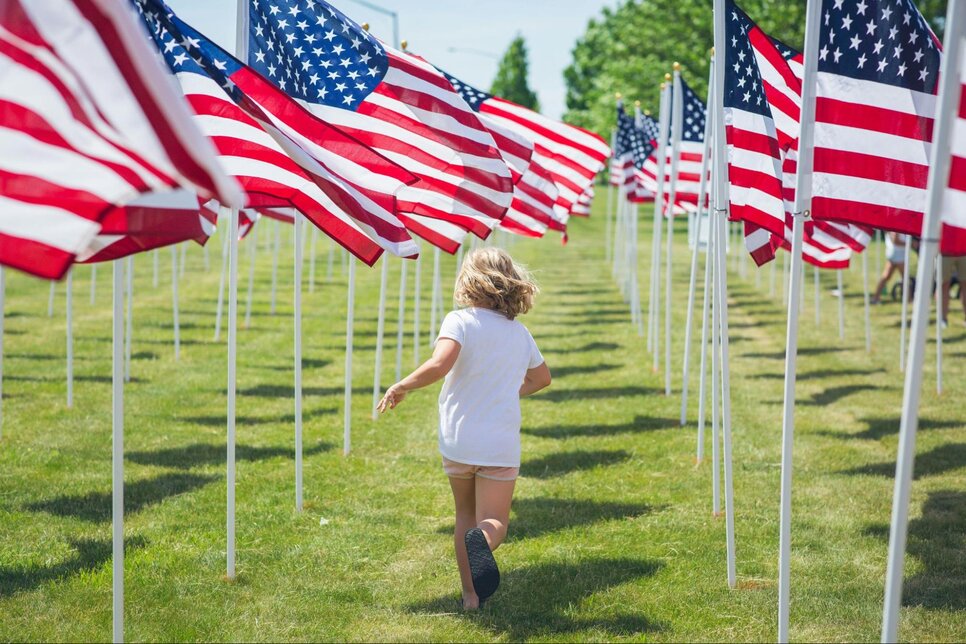 Child running between United States flags