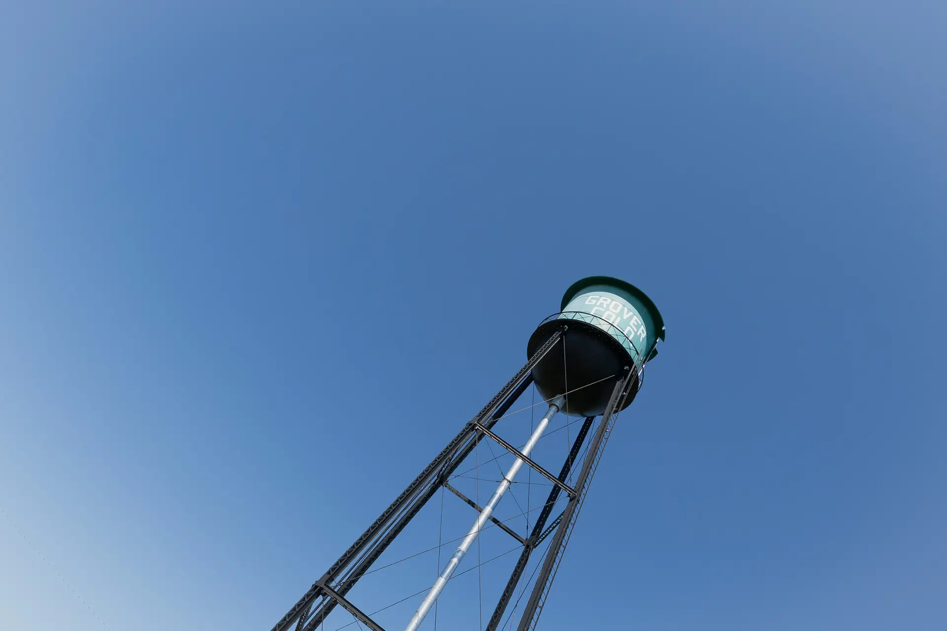A turquoise water tower stands near the rodeo grounds.
