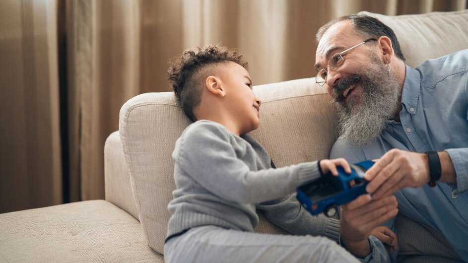 A little boy and his caregiver sitting on the couch.