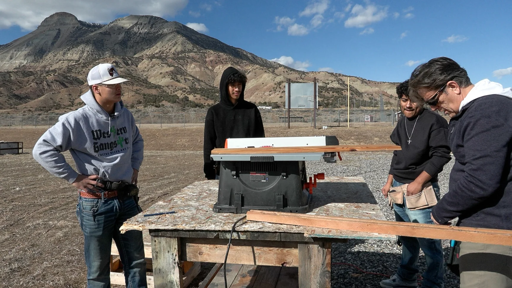 Sione Clegg (left) prepares to cut a cedar board for the siding of the tiny home at Grand Valley High School. Photo: Joshua Vorse, Rocky Mountain PBS