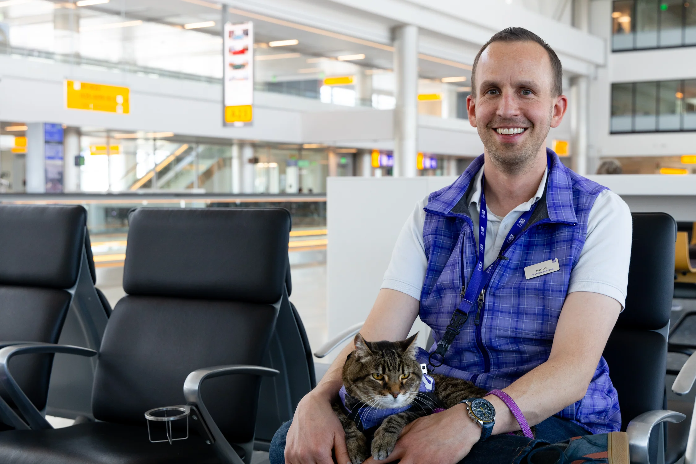 Nathan Pensack-Rinehart volunteers at the airport with his 13-year-old cat, Xeli. Photo: Andrea Kramar, Rocky Mountain PBS