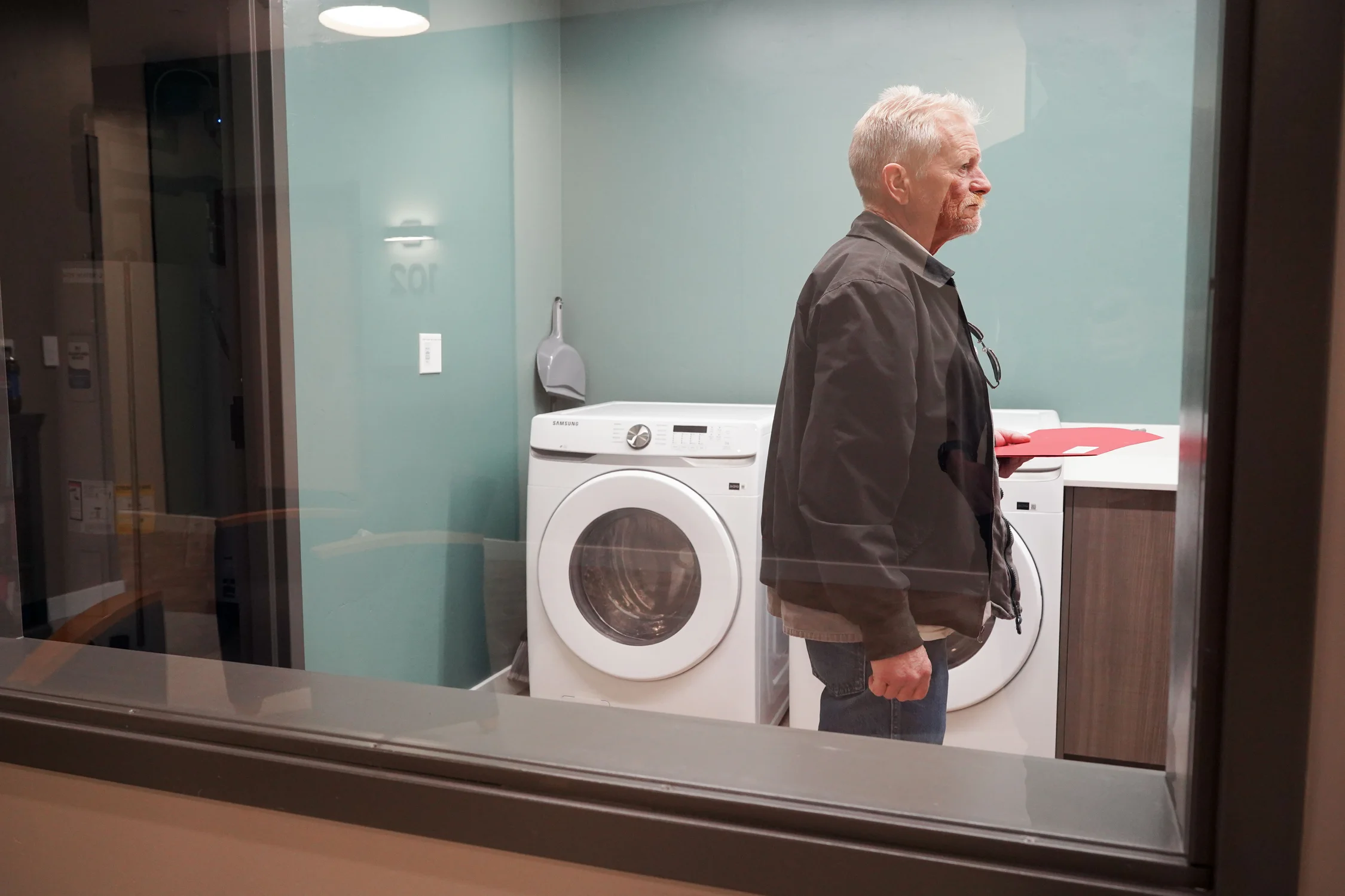 Elmore visits the laundry room across the hall from his apartment during a short tour of the building. Each of the three floors has its own shared laundry room. Photo: Joshua Vorse, Rocky Mountain PBS