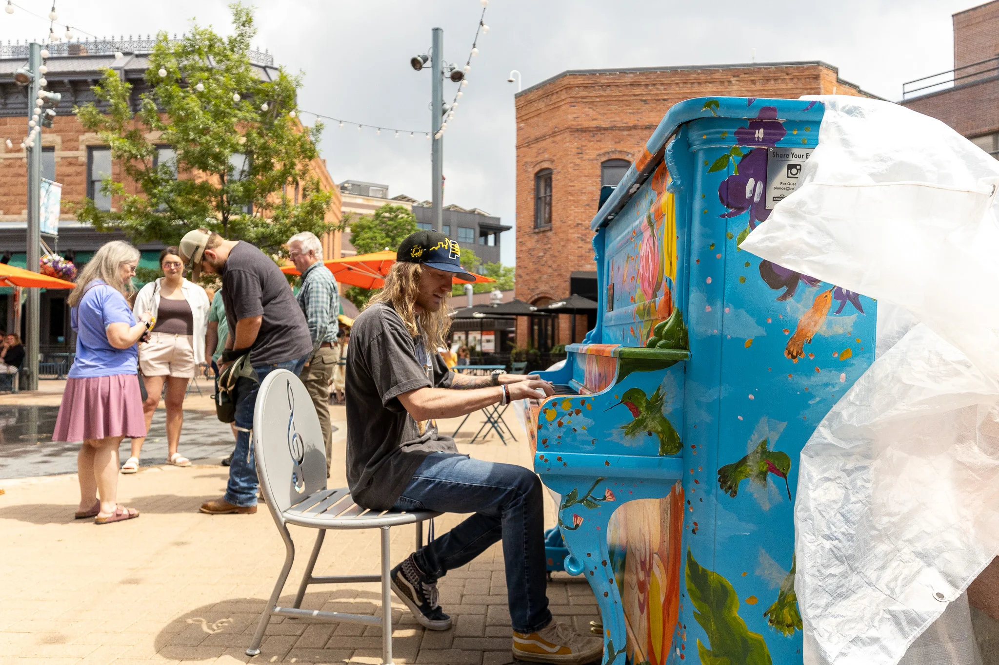 Rovi Hughes performs at a piano in Old Town Square in Fort Collins, Colorado. Photo: Cormac McCrimmon, Rocky Mountain PBS