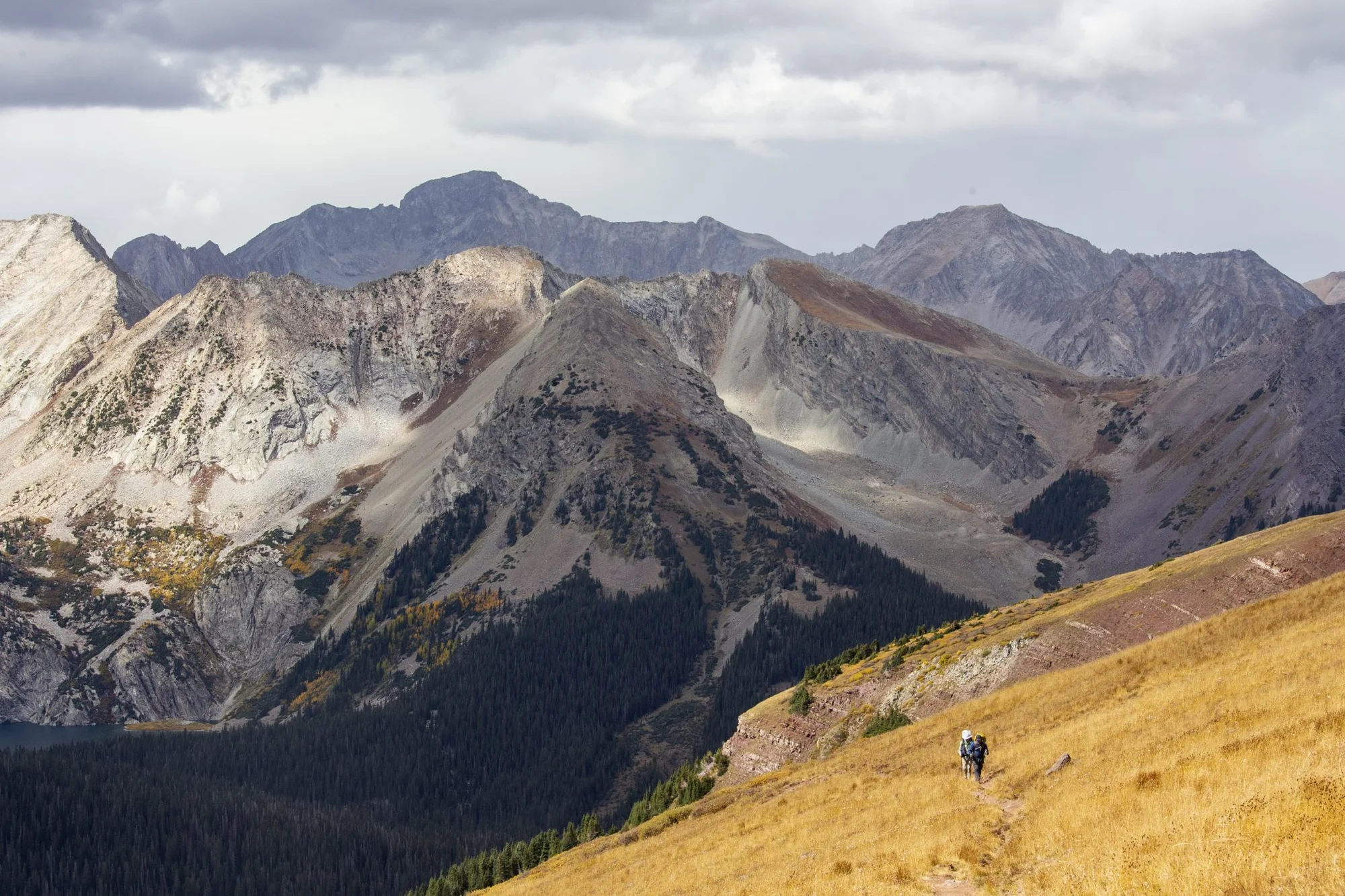 Two hikers climb up Buckskin Pass while completing the Four Pass Loop, a popular backpacking route near Aspen, on Sept. 28, 2022. Backcountry camping permits and fees were implemented in 2023 for overnight stays in popular parts of Maroon Bells-Snowmass Wilderness, such as the Four Pass Loop. Photo: Andrew Maciejewski, Summit Daily News