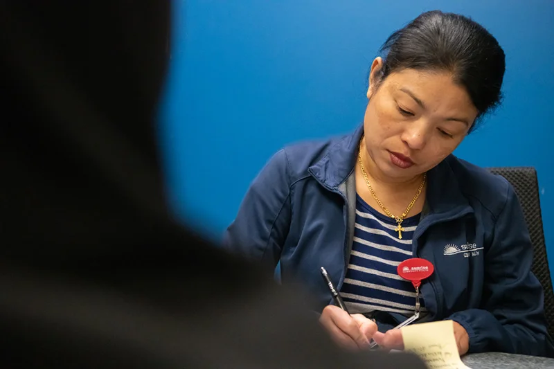 Interpreter Paw Hsa helps a client fill out paperwork on Wednesday, June 18, 2025, at Monfort Family Clinic in Evans, Colorado. Photo: Tanya Fabian, special to The Colorado Trust